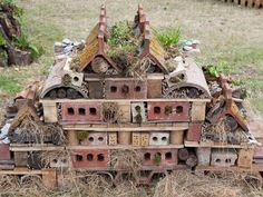 a pile of birdhouses sitting on top of dry grass