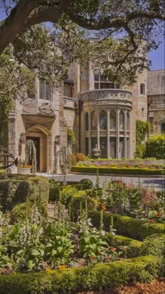 a large house with lots of plants in the front yard and trees on either side