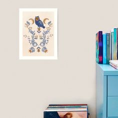 a blue dresser with books on it next to a white wall and a book shelf