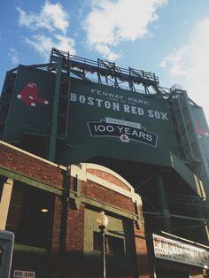 an old boston red sox stadium sign on the side of it's building in front of a blue sky