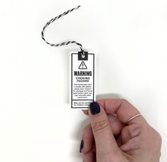 a hand holding a warning label on a white background