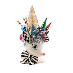 a white ceramic animal with a colorful hat on it's head is decorated with multicolored ornaments