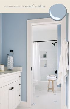 a bathroom with blue walls and white cabinets