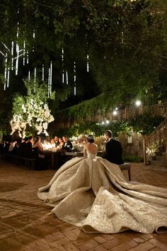 the bride and groom are sitting at their wedding reception in front of an outdoor dining area