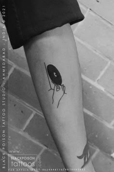 a black and white photo of a person's arm with a record player tattoo on it