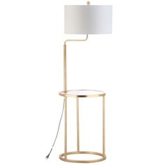 the floor lamp has a white shade on it and is next to a metal stand