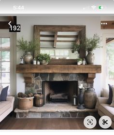 a living room filled with furniture and a fire place in front of a mirror on the wall