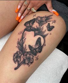 a woman's thigh with butterflies and flowers on the lower part of her leg