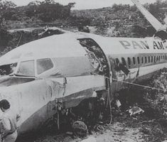 an airplane that is on the ground with people around it and another plane in the background