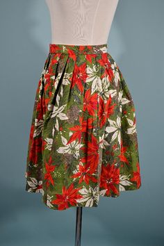 "Very cute 1950s novelty floral print skirt with a high waistband. The floral print depicts poinsettias, leaves, and pinecones. Pleats below waistband. There is no zipper, although one could be added. It closes with hook and eye. The waist is adjustable due to the hook and eye closure. This skirt looks as if it was handmade. LABEL: no label. Might be handmade. SIZE: All sizing given is approximate. **Refer to measurements for accurate fit. MEASUREMENTS Waist: 13 1/4 double to 26 1/2\" *this can Mexican Skirts, Camel Wool Coat, Skirt Winter, Festival Skirts, Poinsettia Flower, Flower Skirt, Full Circle Skirts, Floral Print Skirt, Lace Inset