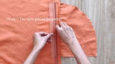 someone is measuring the length of an orange piece of fabric with a ruler on it