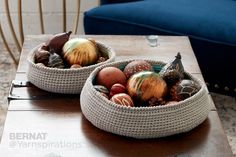 two baskets filled with balls on top of a wooden table