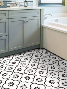 a bathroom with white and black tile flooring next to a bathtub in the corner