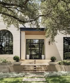 a white house with two large windows and steps leading up to the front door area