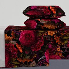 three pillows and two pillow cases on top of each other, with flowers all over them