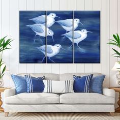 three seagulls in the water on a blue and white background canvas wall art