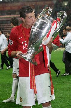 the soccer player is kissing the trophy on the field