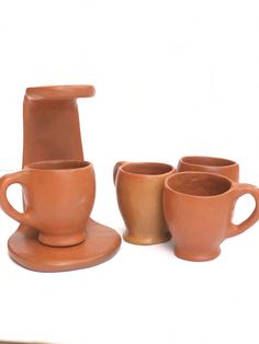 four clay cups and saucers sitting next to each other