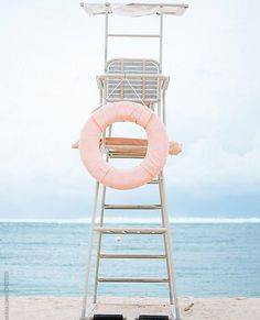 a lifeguard chair on the beach with an inflatable life preserver attached to it