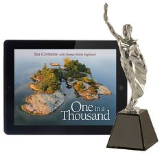 a tablet with a book on it and a silver statue in front of the screen