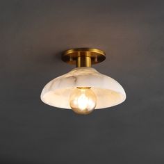 a light that is hanging from the ceiling in a room with gray walls and flooring