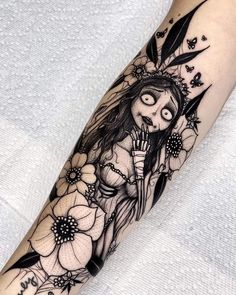 a woman with long hair and flowers on her arm is depicted in this tattoo design