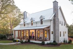 a large white house with lots of windows on the front and side of it's roof