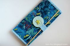 a blue notebook with a yellow starfish on it and two chopsticks sticking out of the cover