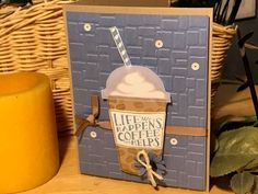 a card with an ice cream sundae on it next to a basket and candle