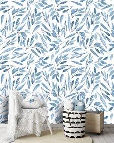 a blue and white wallpaper with watercolor leaves on it in a child's room