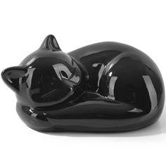 a black cat figurine laying down on its side with it's eyes closed