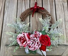 a wreath with red and pink flowers on it