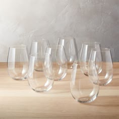 a group of wine glasses sitting on top of a wooden table next to each other