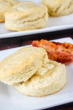 biscuits and bacon are on white plates next to each other