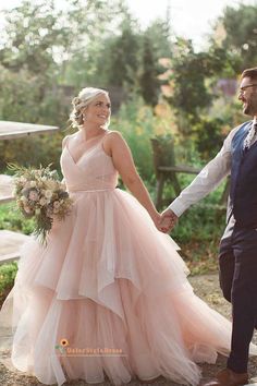 a bride and groom hold hands as they walk together