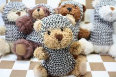 there are many stuffed animals sitting on the checkered tablecloths and one is wearing a knitted hat