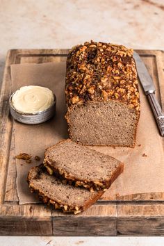 a loaf of bread sitting on top of a wooden cutting board next to a knife