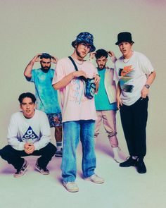 a group of young men standing next to each other in front of a white background