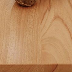 a close up of a wooden surface with a cell phone on the floor next to it