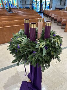 a bunch of candles that are sitting on a table in front of some pews