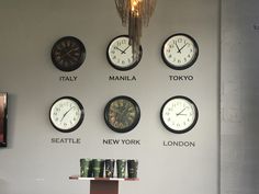 several clocks on the wall with different time zones