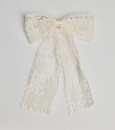 the white lace scarf is tied up with a bow