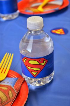 a water bottle sitting on top of a table next to plates and utensils