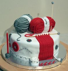 a cake decorated with yarn and knitting needles