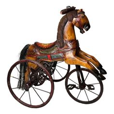 an old fashioned wooden toy horse with wheels on a white backgrounn background