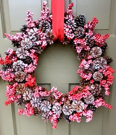 a wreath made out of pine cones and candy canes is hanging on the front door