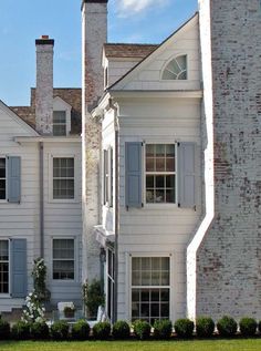 a white house with blue shutters and windows