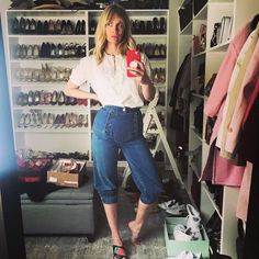 a woman standing in front of a closet full of shoes