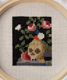 a cross stitch picture with flowers on it