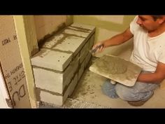 a man is working on some bricks in the bathroom